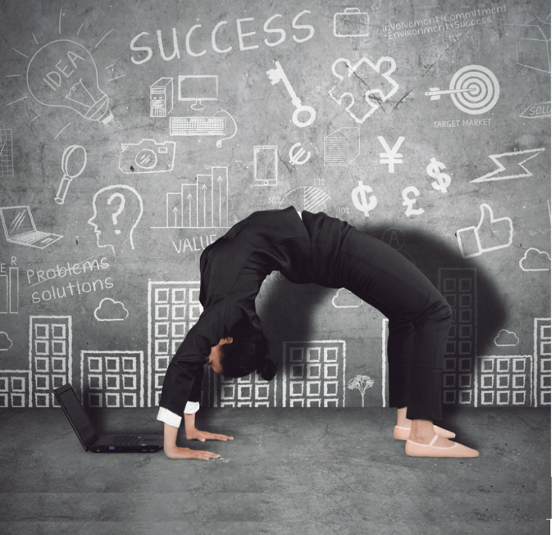 A woman in a business suit in a backflip pose facing a laptop