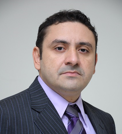 headshot photo of a middle aged dark haired man.